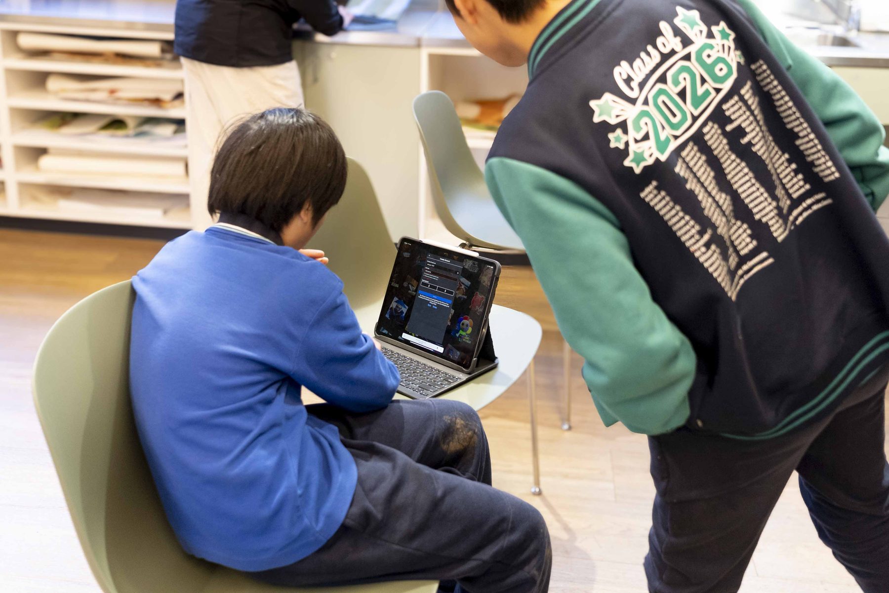 A teen using a tablet during a session, seen from behind